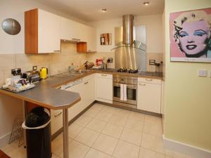 a kitchen with white cabinets and a counter top at Marina Secret in Poole