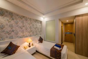 a hotel room with a bed and a chair at Nipola Hotel - Chợ Đêm Dương Đông Phú Quốc in Phú Quốc