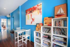 a room with a table and a book shelf with books at OYO 1054 Phuket Backpacker Hostel in Phuket