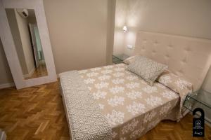 a bedroom with a large bed with a large headboard at Cuencaloft Cervantes in Cuenca