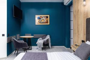 a bedroom with blue walls and a table and chairs at Modern studio apartment in the city of center in Lviv
