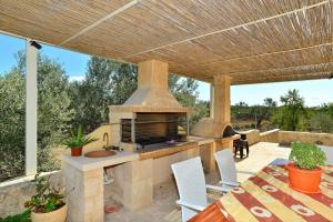 an outdoor kitchen with an outdoor fireplace on a patio at VILLA KONSTANTINOS in Egina