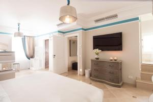 a bedroom with a bed and a tv on a wall at Hotel Don Ferrante in Monopoli