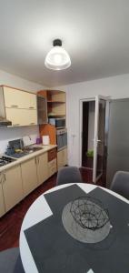 a kitchen with a table and chairs in a room at Apartament Chaplins 3 camere in Piatra Neamţ +4 photos