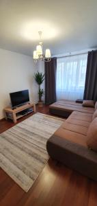 a living room with two beds and a flat screen tv at Apartament Chaplins 3 camere in Piatra Neamţ