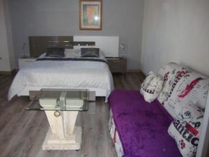 - une chambre avec un lit, une table et un canapé dans l'établissement Le Soleil Bleu, à Fréjus