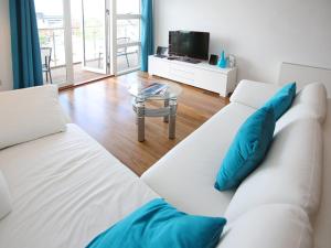 a white couch with blue pillows in a living room at Horizon in Poole