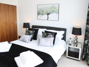 a bedroom with a large bed with black and white pillows at Horizon in Poole