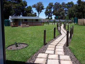 een pad in een veld met een huis op de achtergrond bij Nadine's Self-Catering Accommodation in Stormsrivier