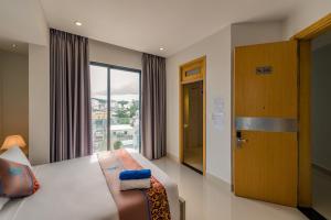 a hotel room with a bed and a window at Nipola Hotel - Chợ Đêm Dương Đông Phú Quốc in Phú Quốc
