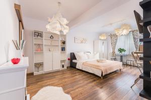 a white bedroom with a bed and a table at Alessia Homes Coressi in Braşov