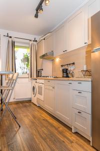 a kitchen with white cabinets and a table and a window at Alessia Homes Coressi in Braşov