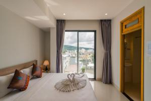 a bedroom with a bed with a swan decoration on it at Nipola Hotel - Chợ Đêm Dương Đông Phú Quốc in Phú Quốc