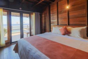 珀尼达岛Waterside inn Nusa Penida的一间带床的卧室，可欣赏海景