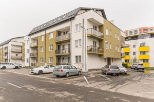 an apartment building with cars parked in a parking lot at Alessia Homes Coressi in Braşov