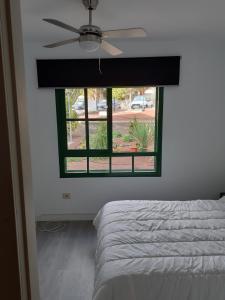 a bedroom with a ceiling fan and a window at Casa Rey in Playa Blanca