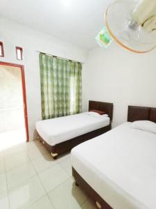 a room with two beds and a window at Aqsa Guest House Banjarsari 