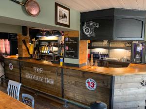um bar com um balcão de madeira num restaurante em The George Inn Middle Wallop em Stockbridge