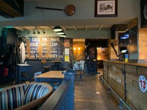 um restaurante com mesa e cadeiras e um bar em The George Inn Middle Wallop em Stockbridge