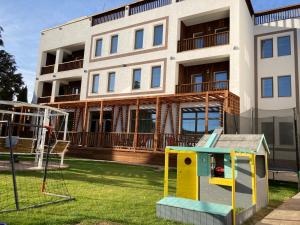 an apartment building with a playground in front of it at Sim House in Gura Humorului