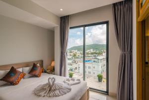 a bedroom with a bed and a large window at Nipola Hotel - Chợ Đêm Dương Đông Phú Quốc in Phú Quốc