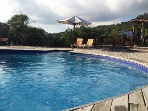 ein großer Pool mit Sonnenschirm und zwei Stühlen in der Unterkunft Media Luna Resort & Spa in First Bight