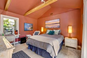 1 dormitorio con paredes de color naranja, 1 cama y ventana en English Garden Studio Suite, en Santa Cruz
