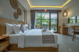 a bedroom with a large bed and a large window at Ranggen Ubud in Ubud