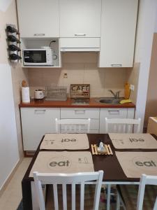 una cocina con mesa y sillas con cajas. en Apartman Lari, en Vlašić
