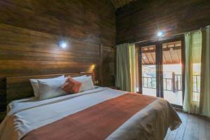 珀尼达岛Waterside inn Nusa Penida的一间带床和大窗户的卧室