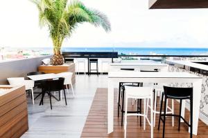 a dining room with a bar and a view of the ocean at MARQUEE Playa Hotel in Playa del Carmen