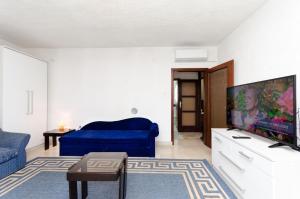 salon z niebieską kanapą i telewizorem z płaskim ekranem w obiekcie House Andrijana w Novim Vinodolskim