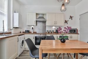 a kitchen with a wooden table with chairs and a dining room at Heart of the City-Flexi Cancellations-Central Hub in Sheffield