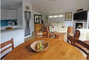a kitchen and living room with a wooden table with a bowl of fruit at Astbury Falls Luxury Retreats in Eardington