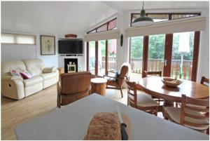 een woonkamer met een bank en een tafel en stoelen bij Astbury Falls Luxury Retreats in Eardington