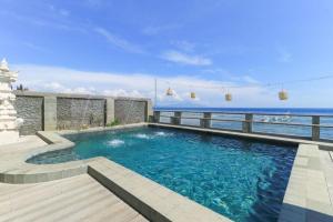 a swimming pool with a view of the ocean at Waterside inn Nusa Penida in Nusa Penida