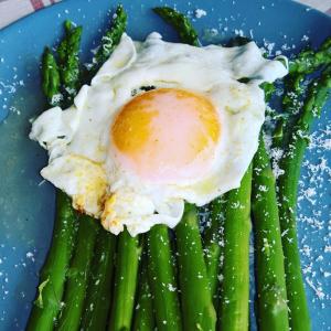 a blue plate with an egg on top of asparagus at Agriturismo Serec in Angolo Terme