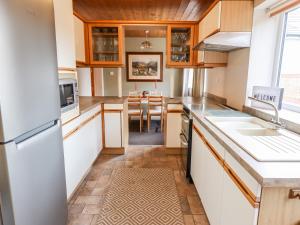 a kitchen with white cabinets and a dining room at 3 Springhaven in Harrogate