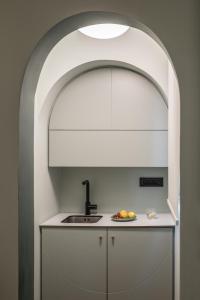 a kitchen with a sink and an archway at Domus Ariadne in Heraklio Town