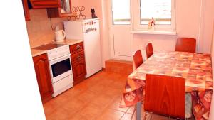 モスクワにあるApartment Na 3ey Marinoy Roshiのキッチン(テーブル、椅子、冷蔵庫付)