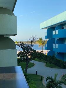a view of a building with the ocean in the background at Lindo apto em Arraial do Cabo condomínio Golden Lake in Arraial do Cabo