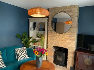 a living room with a blue couch and a fireplace at Boutique home near Chichester centre in Chichester
