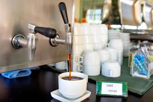 un café vertido en una taza en un mostrador en Yak Beach Hotel Ponta Negra, en Natal