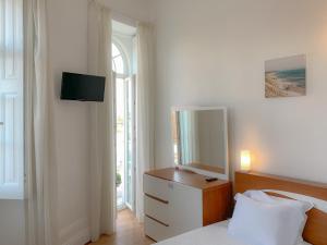 
a bedroom with a bed and a dresser at Alojamento Tricana de Aveiro in Aveiro
