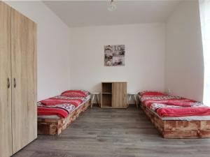 2 camas en una habitación con paredes blancas en byt s balkonem, en Žatec