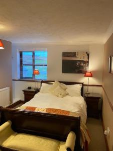 a bedroom with a bed, a desk and a lamp at Blackthorn Farm in Holyhead