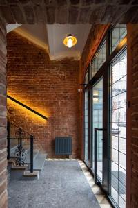 a brick wall with a bench in a room with windows at Four Rooms City in Kharkiv