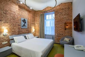 a bedroom with a bed and a brick wall at Four Rooms City in Kharkiv