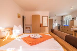 a room with a bed with an orange pillow on it at Ferienhof Sauter Lindau in Neukirch +11 photos
