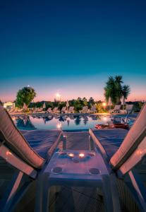 Erofili Hotel في كافوس: اطلالة على مسبح مع كرسيين وطاولة